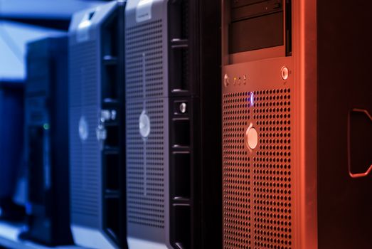 Home Close-up of tower servers in a data center with blue and red lighting.